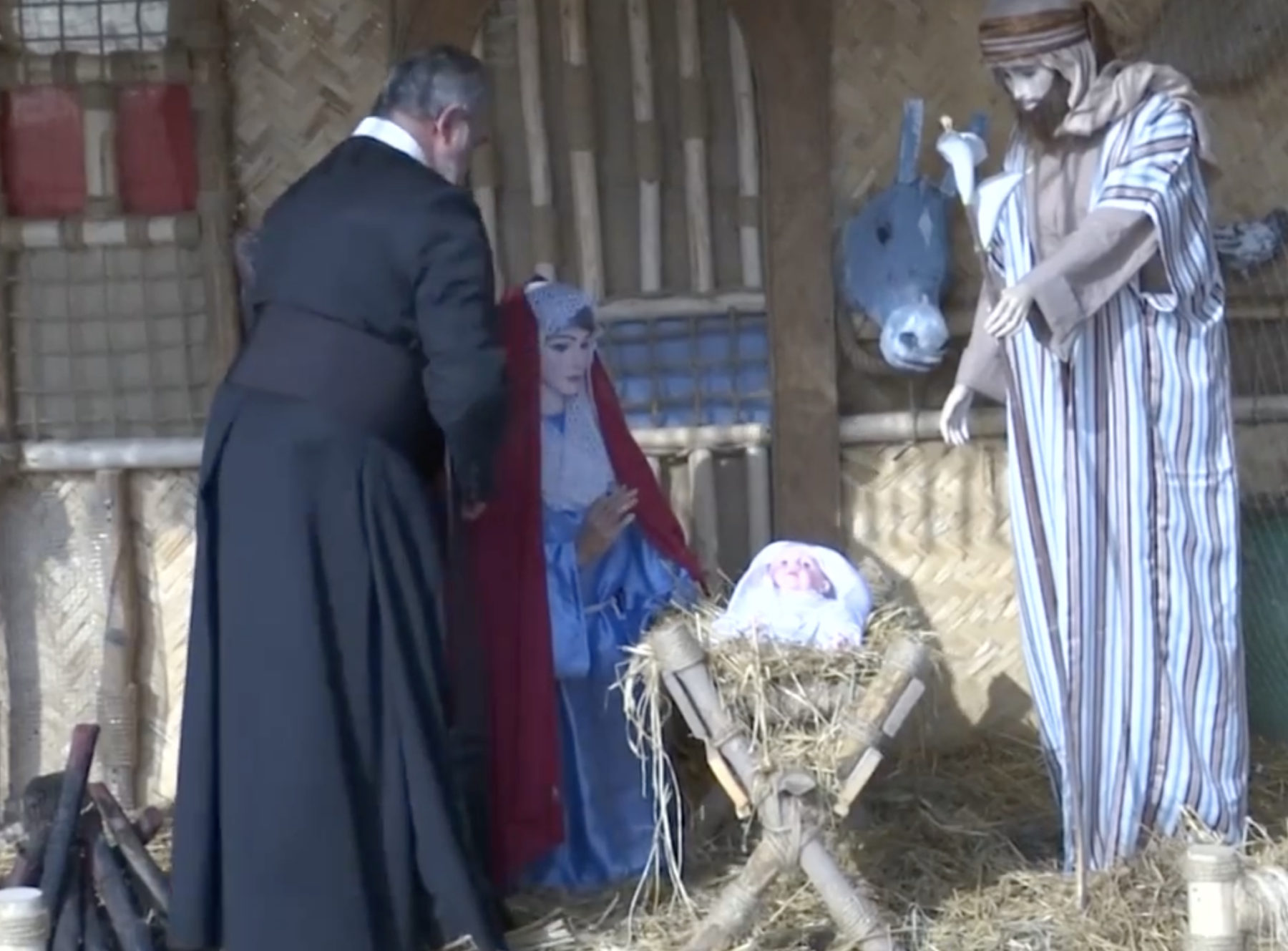 Prêtre irakien installant une crèche à Noel