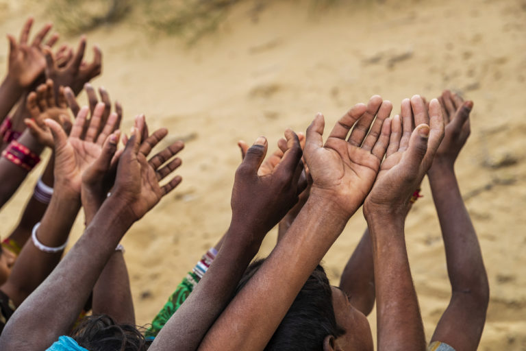 Des enfants pauvres indiens gardent leurs mains levées et demandent du soutien.