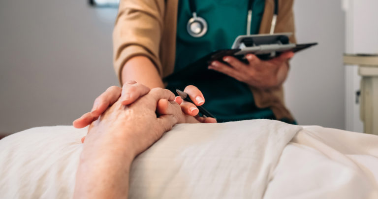 Une jeune femme médecin rassurant un patient âgé