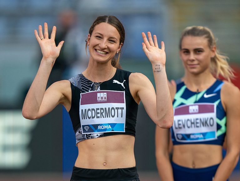 La sauteuse en hauteur australiennne Nicola McDermott sourit et salue la foule lors de la Diamond League à Rome en octobre 2020.. Sur son poignet se trouve une croix dessinée au marqueur et les mots «pour sa gloire».