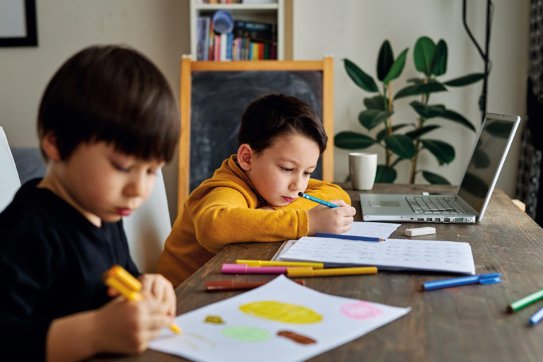 Deux enfants étudient à une table.