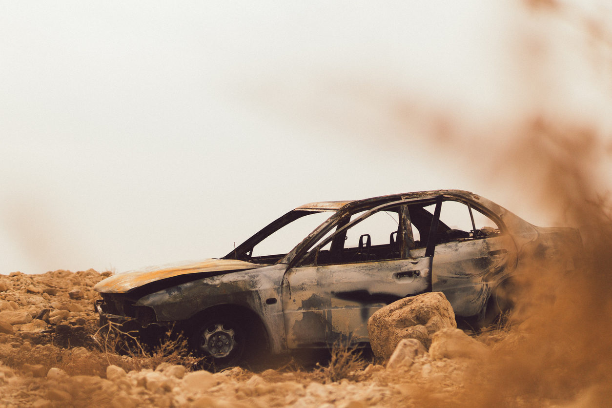 Voiture brûlée abandonnée dans le désert.