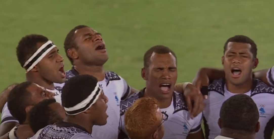 Groupe de rugby à 7 fidjien louant Dieu sur le terrain