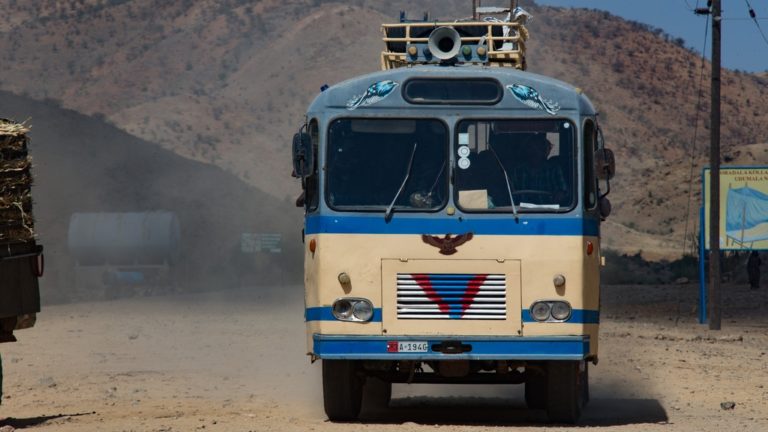 Bus de face sur une route sableuse