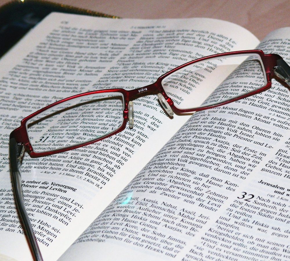 Une paire de lunettes posée sur une Bible ouverte
