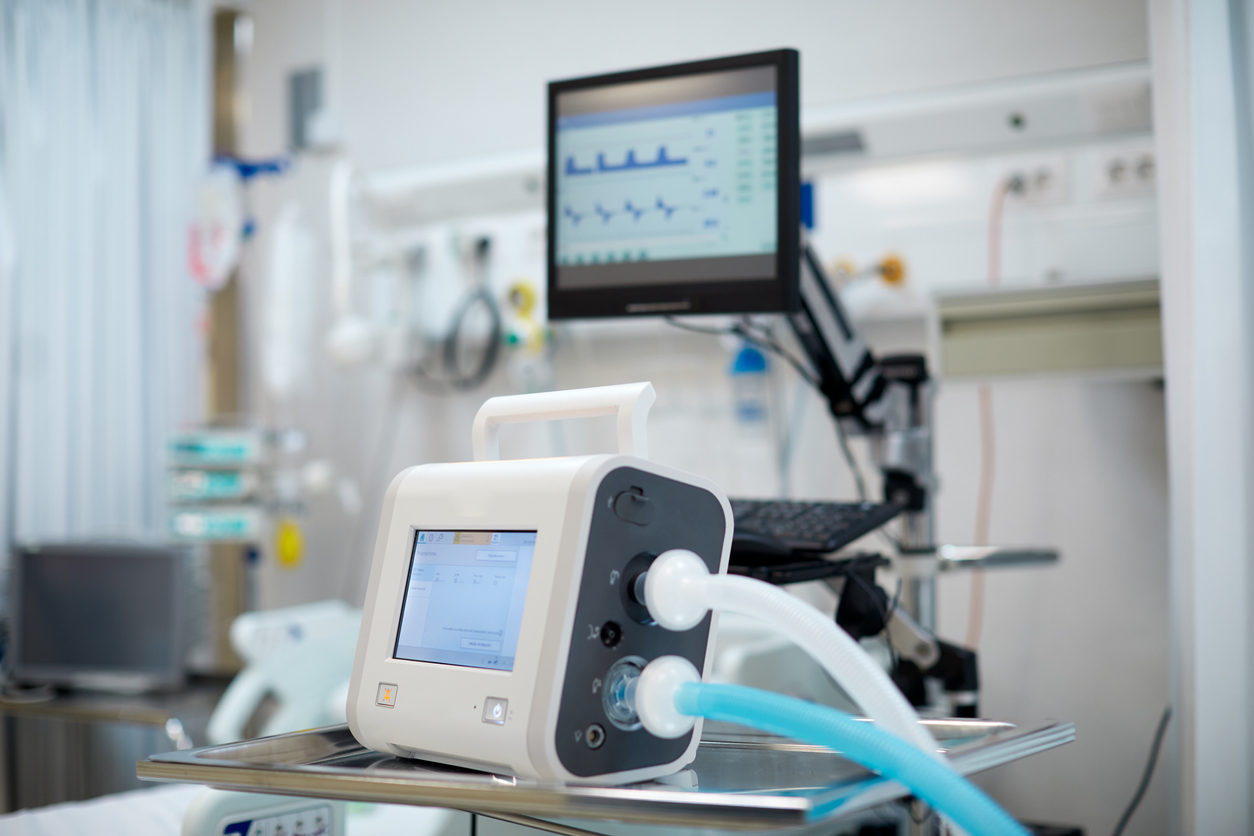 Dans une chambre d'hôpital, un concentrateur d'oxygène et un moniteur de fréquence cardiaque