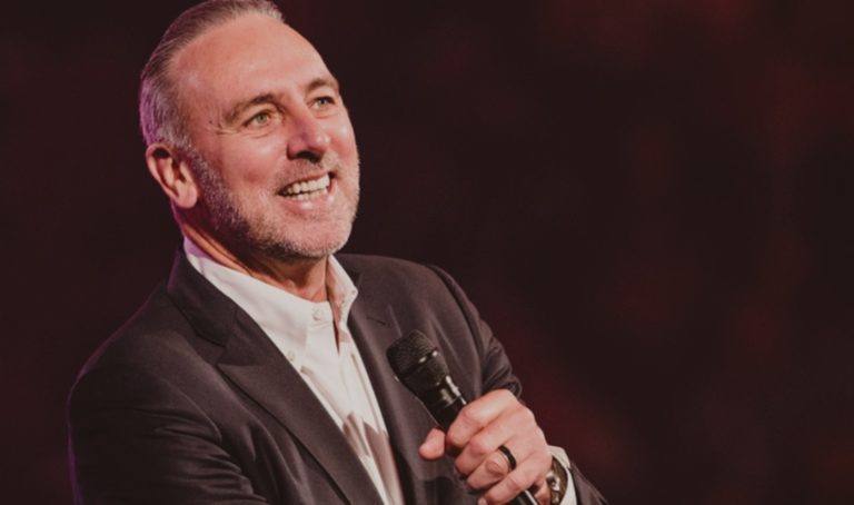 Brian Houston, souriant, parle dans un micro