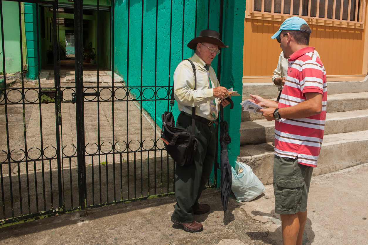 Un homme donne un tract à un autre dans la rue