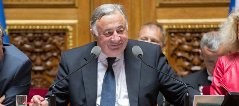 Gérard Larcher, homme corpulent aux cheveux grisonnants et costume gris. Il parle dans un micro