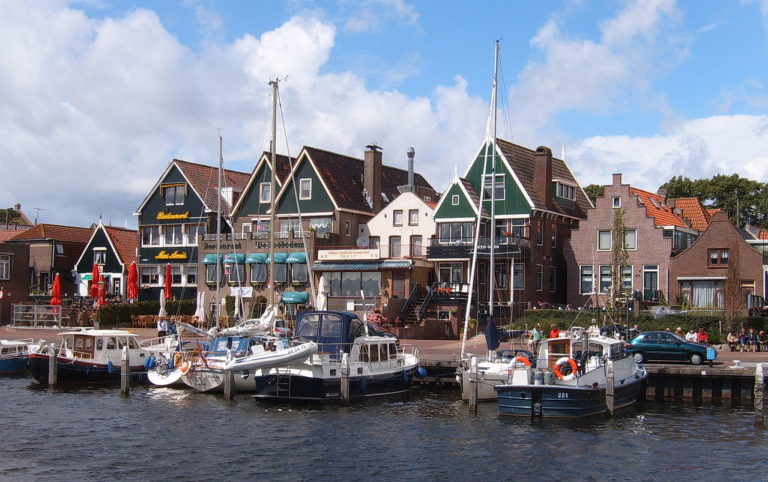 Le port d'Urk, vu depuis la baie. Des bateaux de pêcheurs sont amarré non loin d'une rangée de maisons colorées