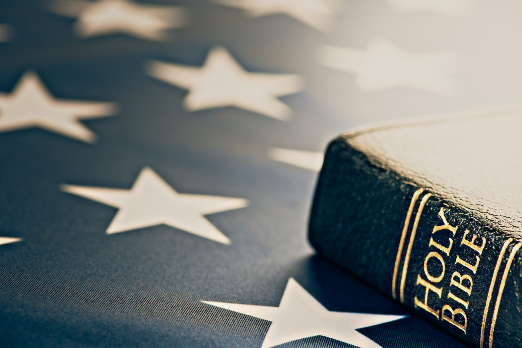 Vu de près, le coin d'une Bible noire sur le motif étoilé du drapeau américain