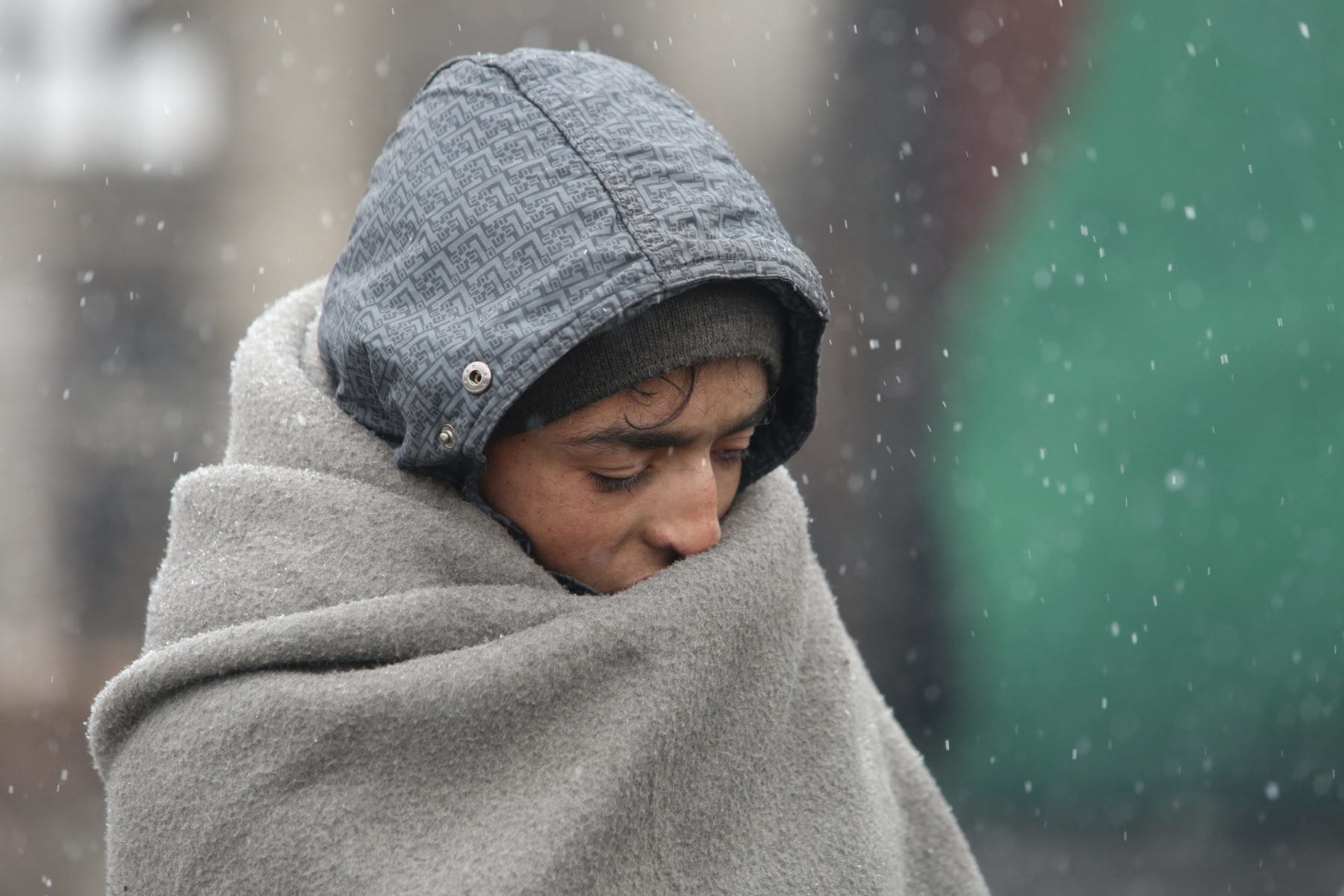 Une jeune femme du Moyen Orient, tête baissée, enveloppé d'une couverture grise