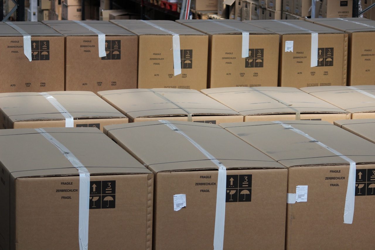 Des cartons, tous les mêmes, sont rangés dans un entrepôt