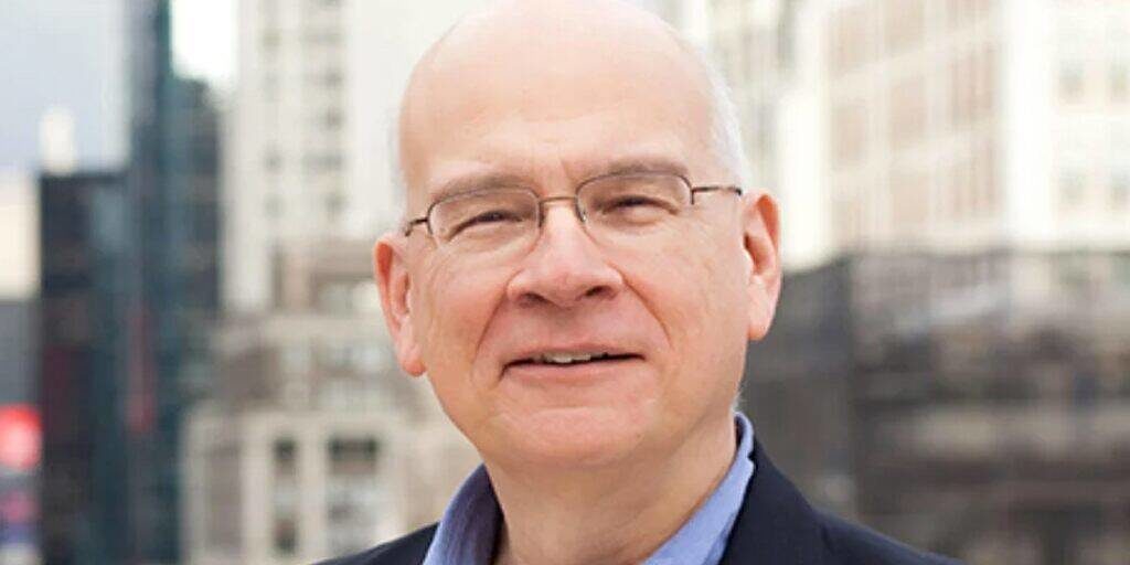 Tim Keller. Il est presque chauve avec des cheveux blancs sur les côté. Il regarde droit vers l'objectif. Il a l'air naturel, sans prendre la pause.