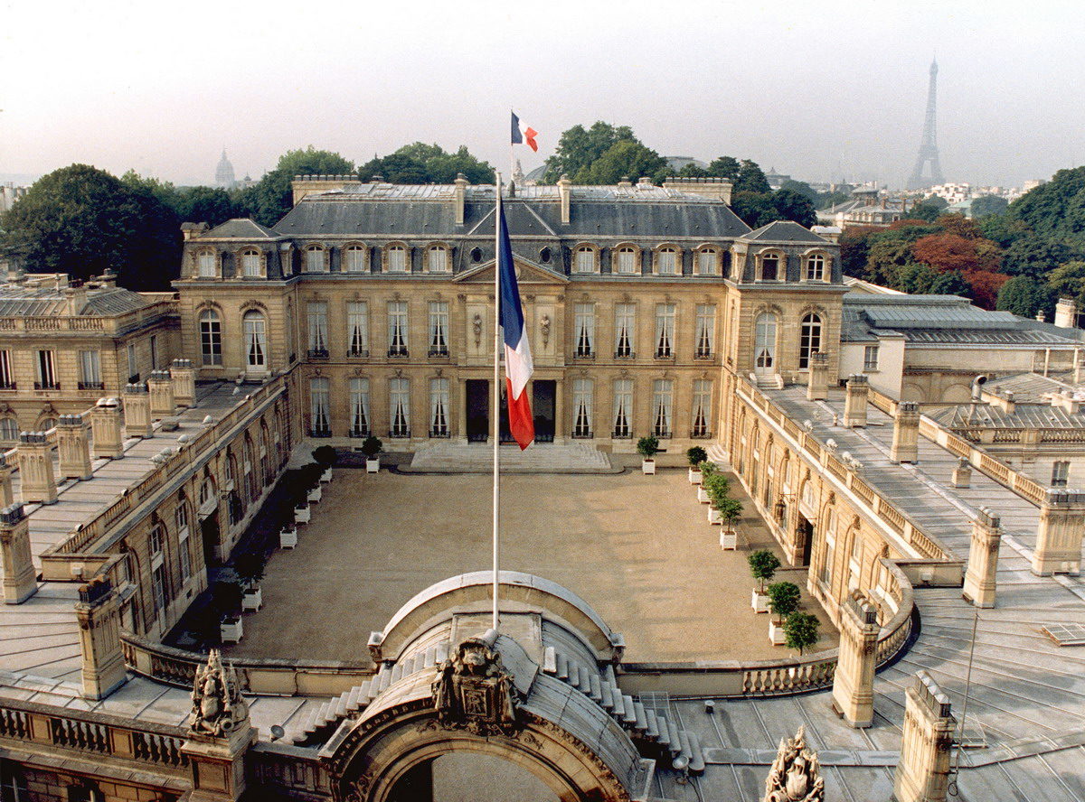 Vue en plogé du palais de l'Elysée, avec sa cour interieure. Au premier plan, le drapeau français, fixé sur une arche en pierre.