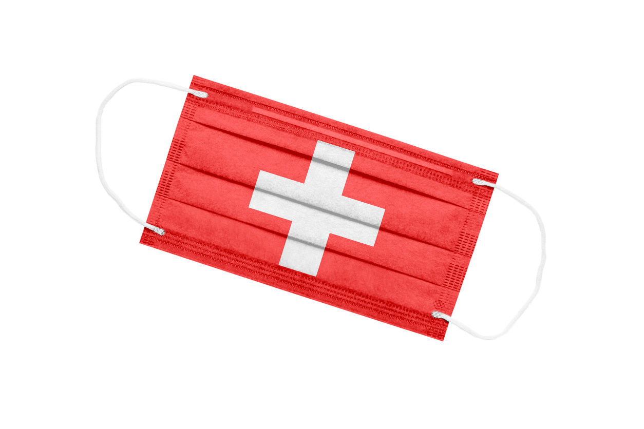 Photo d'un masque anti-covid rouge figurant le drapeau suisse