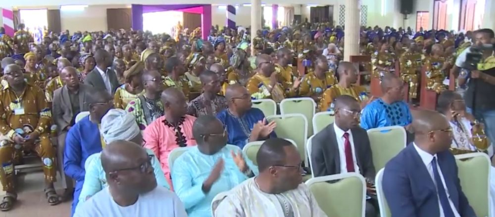 Une foule de béninois est assise dans une salle de culte.