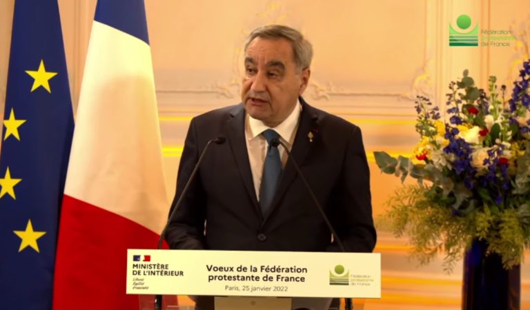 François Clavairoly, 64 ans, parle derrière un pupitre. Il est face à l'objectif, la tête légèrement tournée vers la gauche et semble regarder quelqu'un en particulier. Derrière lui à gauche, le drapeau français et le drapeau de l'Europe. Une pancarte sur le pupitre indique: "Voeux de la fédération protestante de France".