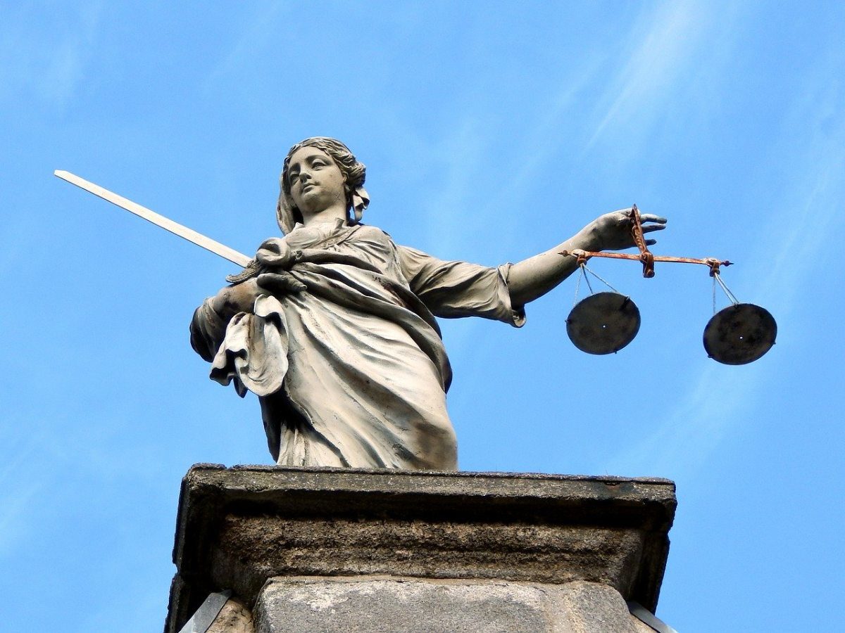 Vue en contre-plongée d'une statue représentant la justice. Elle tient une balance et une épée.
