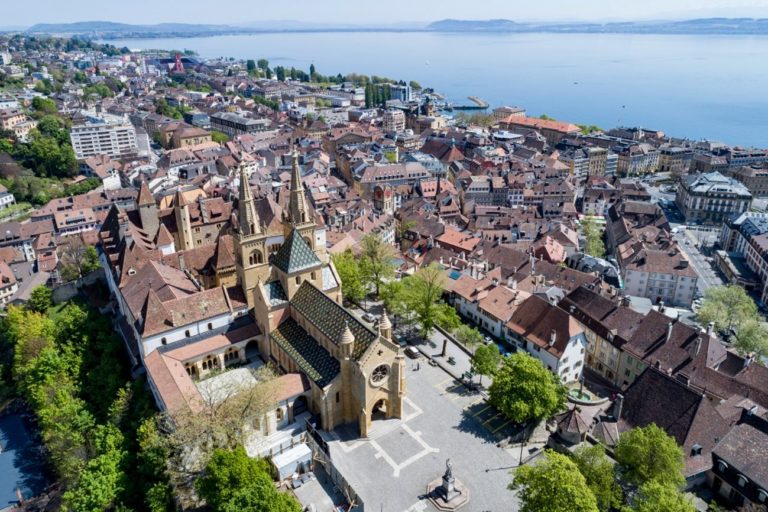 Vu aérienne de la ville de Neuchâtel, au bord du lac. On voit notamment une multitude de toits bruns et brun clair