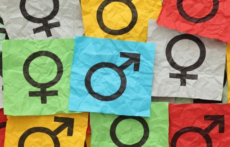 Des carrés de papier multicolores représentent les symboles féminins et masculins.