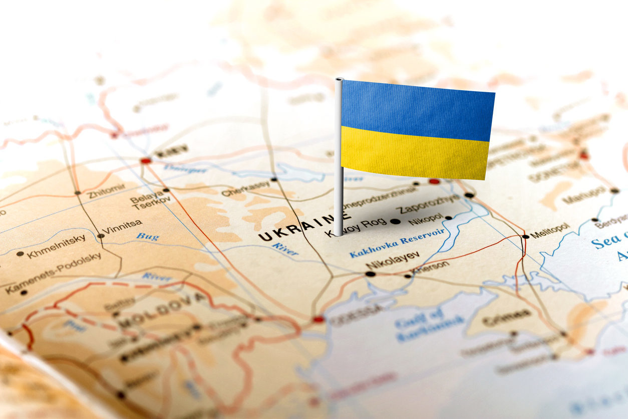 Un petit drapeau ukrainien est planté sur une carte où se dessine l'Ukraine