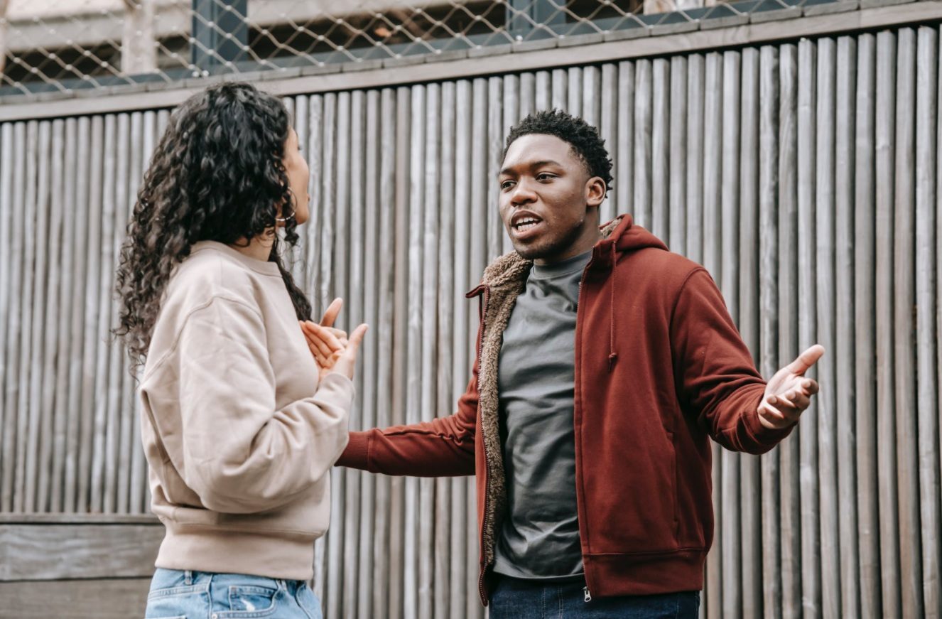 Un jeune homme et une jeune femme se disputent dans la rue