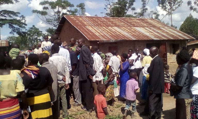 Dans un pays d'Afrique, quelques dizaines de personnes sont rassemblées. Elles regardent toutes dans la même direction. On ne vit pas la tombe, mais c'est un enterrement. Le groupe est près d'une maison qui a un toit en tôles.