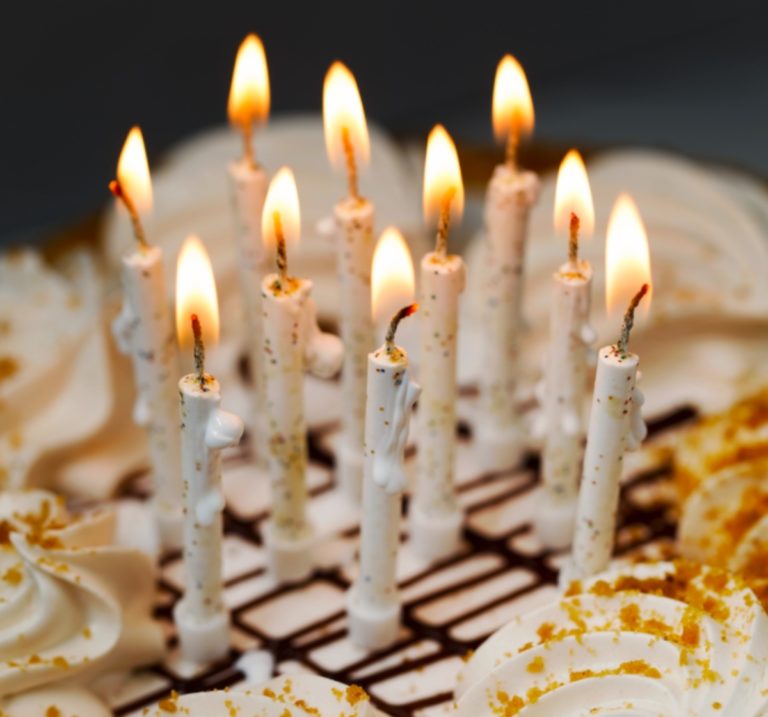 Une dizaine de bougies sont allumées sur un gâteau.