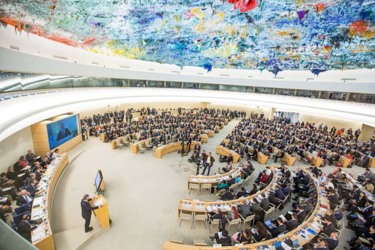 Conseil des Droits de l'homme de l'ONU. Des centaines de personnes sont alignées en demi-cercle autour d'un orateur.