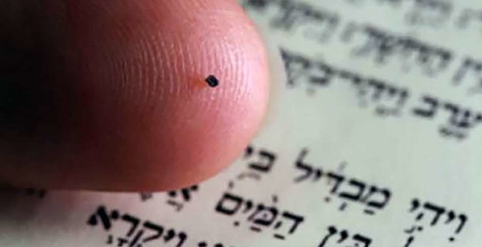 Sur la pointe d'un doigt, un minuscule cube noir est posé. C'est une nano Bible