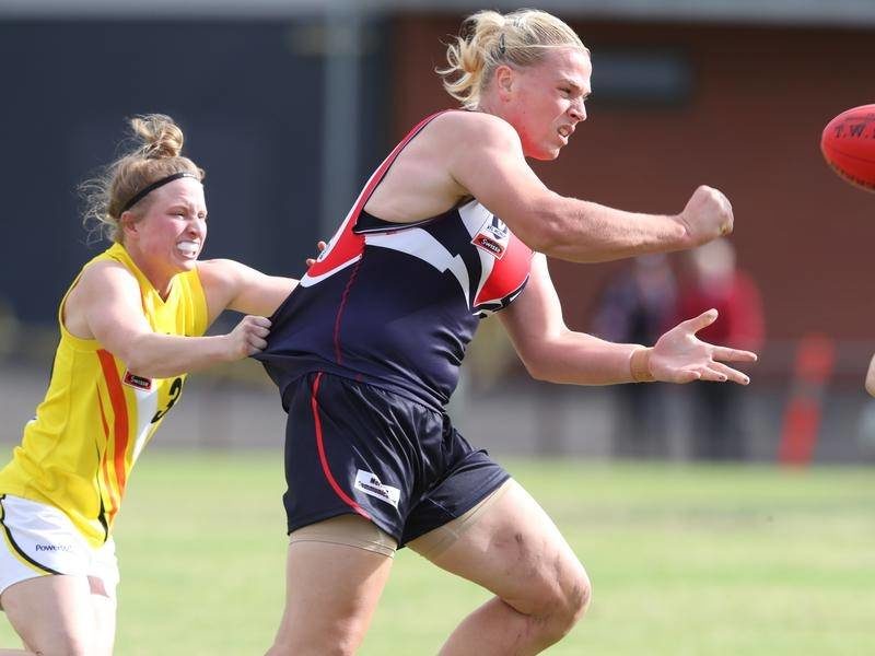 Durant un match de rugby, une sportive tente de toute sa force de retenir une femme transgenre, beaucoup plus musclée qu'elle.