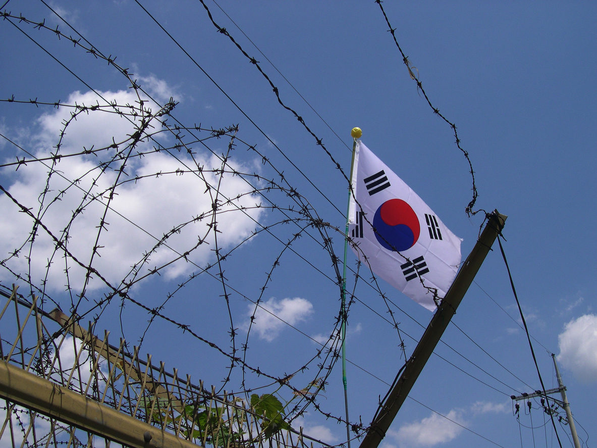Un drapeau nord-coréen flotte sur un grillage barbelé