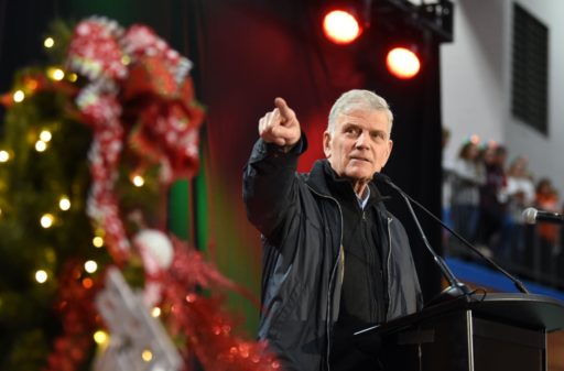 Franklin Graham prêche, la main levé devant lui.