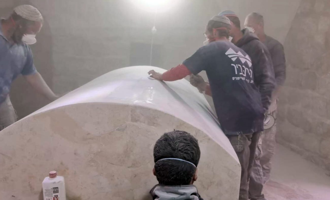 Quelques ouvrier réparent le cercueil en pierre massive.