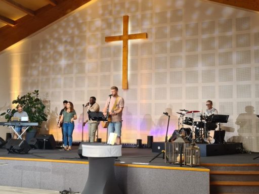Plusieurs musiciens jouent sur la scène d'une Eglise.