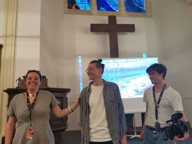 Elsie Pomier, Estienne Rylle et Alban Robert tout sourire au premier plan devant l'écran de projection du temple protestant de Cannes