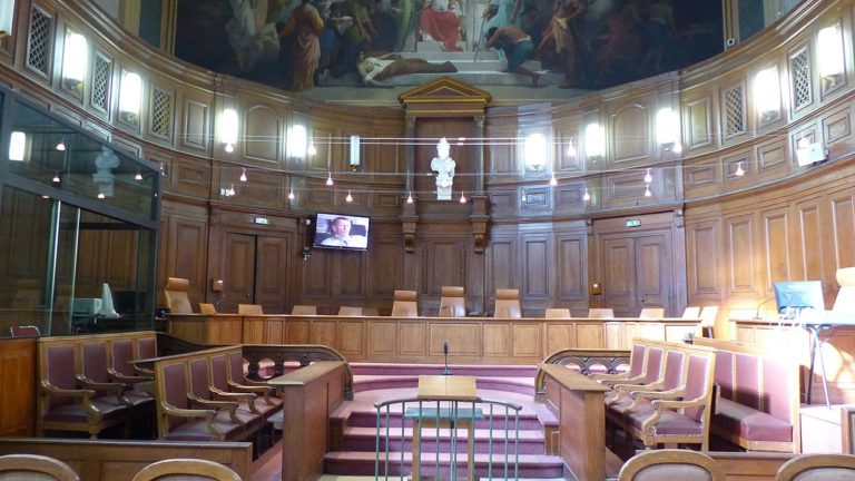 Photo de l'intérieur d'un tribunal. Tout le mobilier et les murs sont en bois.