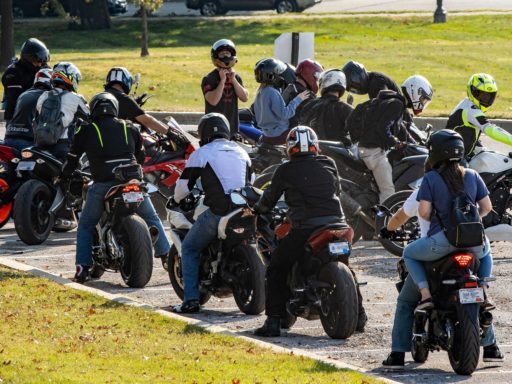 Un groupe de motards est rassemblé sur un parking entouré de pelouse