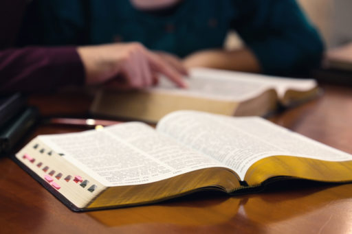 Une personne pointe des versets du doigt dans une Bible.