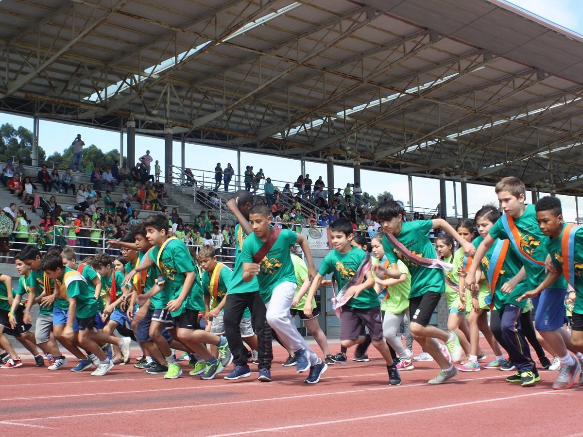 Des enfants vêtus de vêtements de sport courent sur une piste d'athlétisme