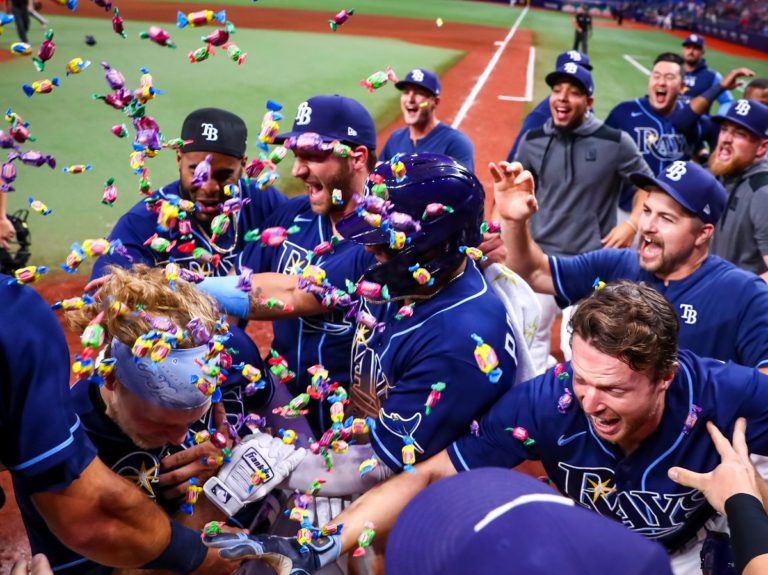 Des joueurs de baseball vêtus de bleu fêtent la victoire sous une pluie de cotillons multicolores