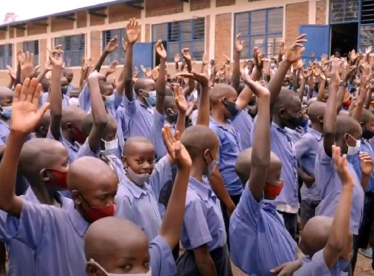 Des enfants rwandais lèvent la mains pour signifier leur volonté de s'engager dans la foi
