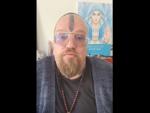 Riaan Swiegelaar, tatoué sur le visage et barbu, fait face à la caméra