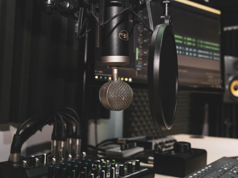 un studio de radio avec une table de mixage, un micro d'enregistrement et un ordinateur