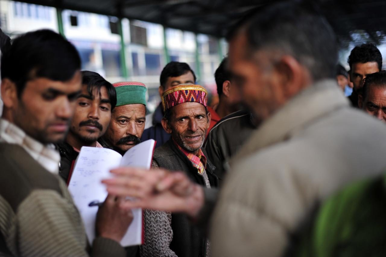 Un groupe d'hommes indiens est réuni en extérieur.