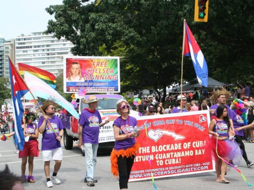 des cubains manifestent, avec des pancartes et des drapeaux, dans les rues de Vancouver (Canada) en 2015 pour réclamer le respect des droits des LGBT
