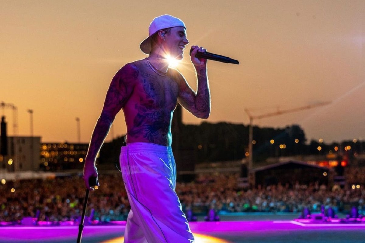 Justin Bieber, torse nu avec ses nombreux tatouages, micro à la main devant la foule à Rio de Janeiro