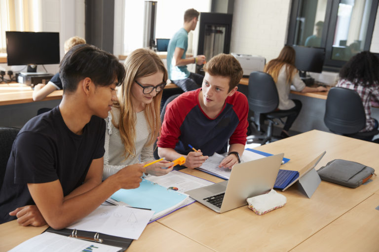 Des étudiants discutent en travaillant