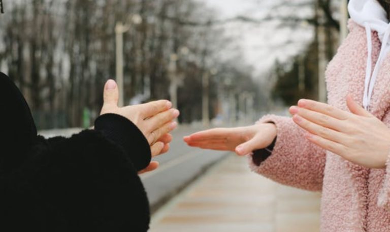 Deux personnes parlent en langue des signes dans la rue.